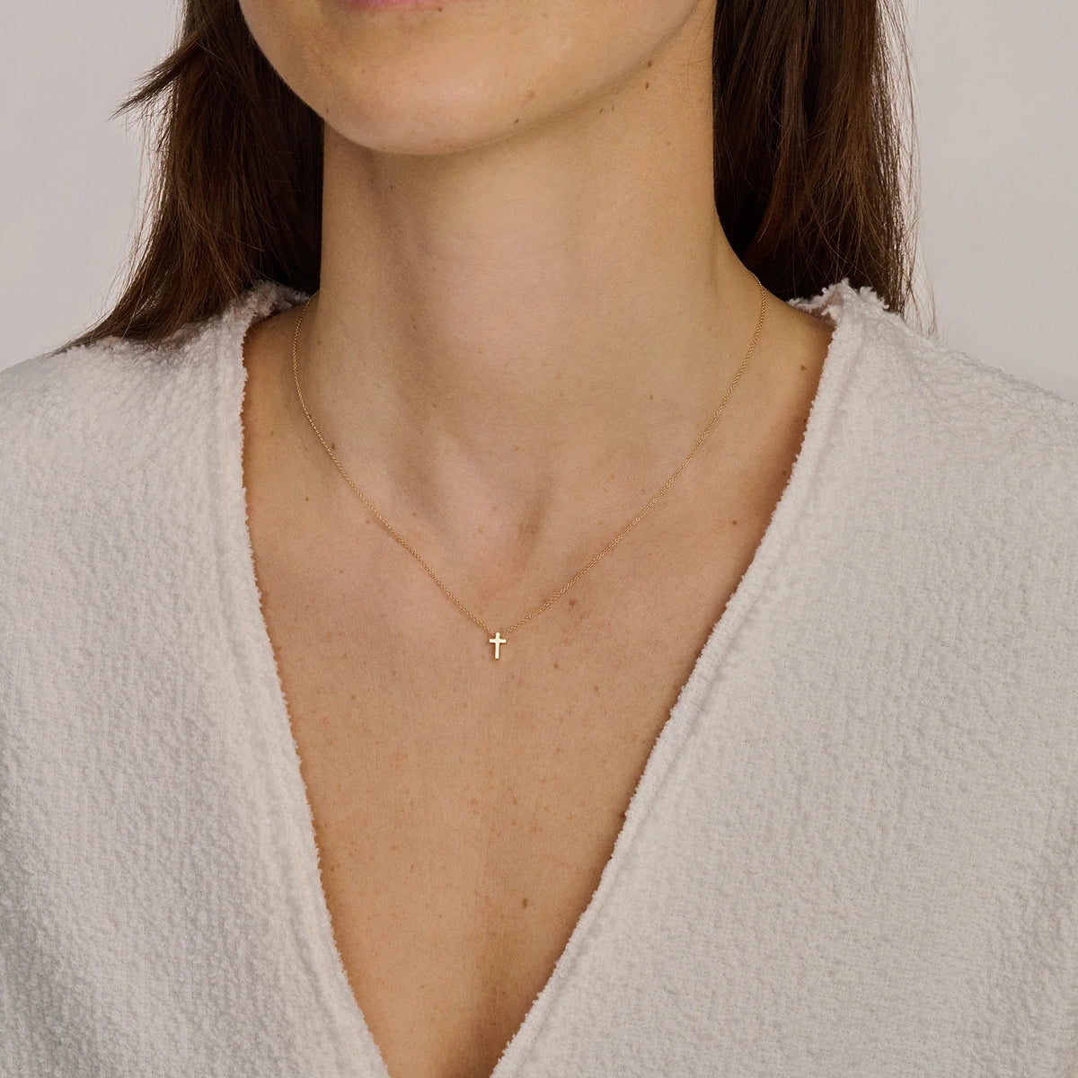 GIORO Collier Liora aus 585er Gelbgold mit zartem Kreuz-Anhänger am Dekolleté eines Models